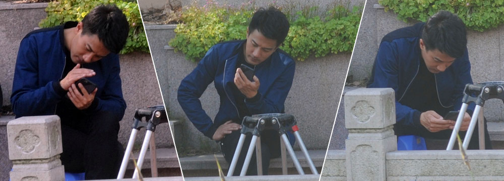 孤独男人的日常 刘恺威独自一人坐石椅玩手机一脸欢笑