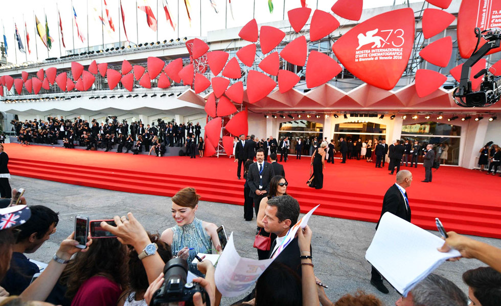 意大利威尼斯当地时间8月31日，第73届威尼斯电影节(the 73rd Venice Film Festival)开幕式，开幕片《爱乐之城 《（La La Land）举行首映礼。评审团成员赵薇黑裙优雅亮相。张雨绮金黄色礼服华美大气。柯震东也亮相红毯勇闯国际舞台。图为艾玛·斯通在电影红毯前签名。