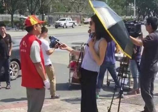 厦门女记者戴墨镜打伞采访救灾志愿者 被停职(图)