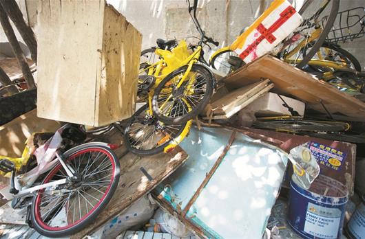 疑因挡道 十多辆共享单车被扔垃圾堆