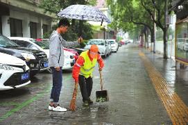 西安大学生雨中为六旬保洁员撑伞40分钟
