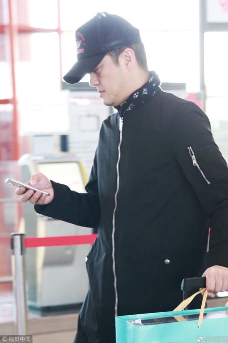 李亚鹏亮相机场 黑衣低调手机刷不停