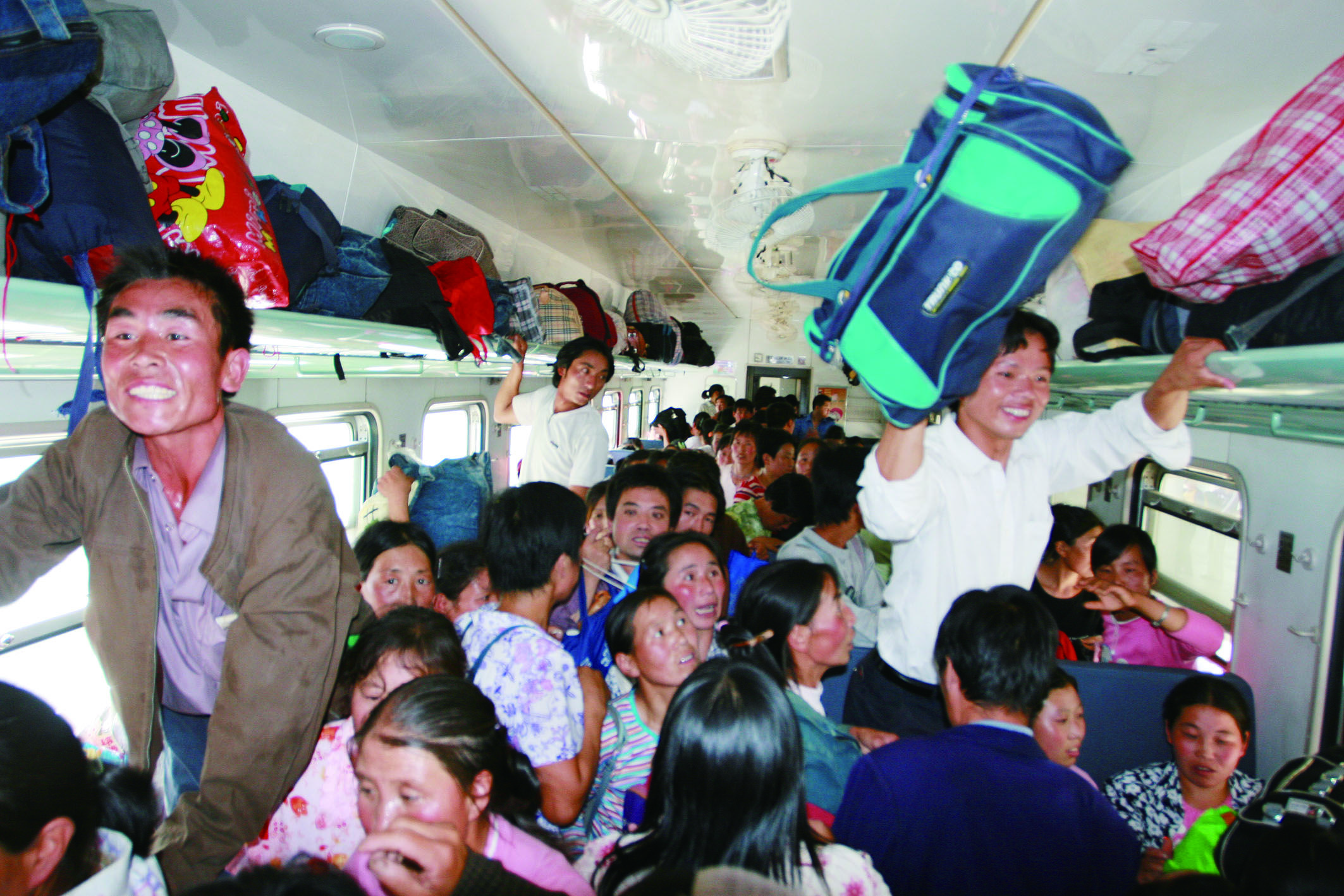 2006年8月21日,从兰州开往新疆的火车车厢里拥挤不堪.曹志政 摄