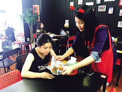 美女老板周思邑为顾客端上花甲米线。