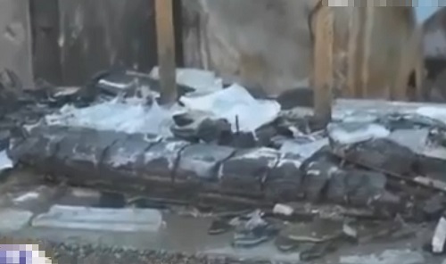 案发现场五间房子的屋顶已经全部被烧塌，在现场也能闻到烧焦的气味。（视频截图）