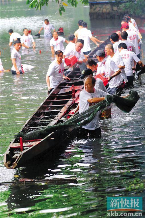 ■荔湾区泮塘村村民于昨日上午举行传统仪式,将埋藏在荔湾湖的3条龙舟从水底挖起。新快报记者 郗慧晶/摄