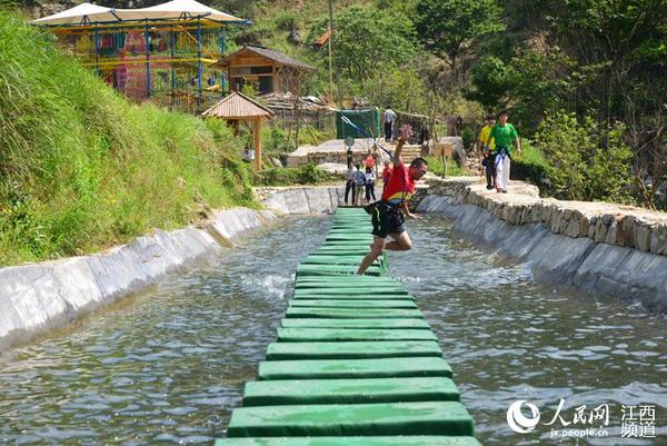 偶尔飞身水中,让水上漂闯关充满趣味。(严荣华/摄)