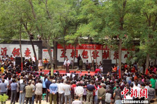 演出现场挤满民众，连四周的房顶都站着很多人。　于俊亮 摄