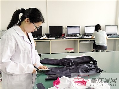 市纤检院检测人员对送检的校服进行检测取样。本报记者 胡杰 摄