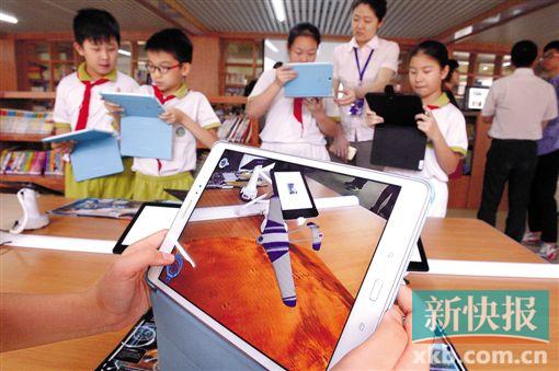 ■华侨小学开放式图书馆配备了iPad、kindle等电子阅读设备,学生可以体验3D动画。　    新快报记者 王飞/摄
