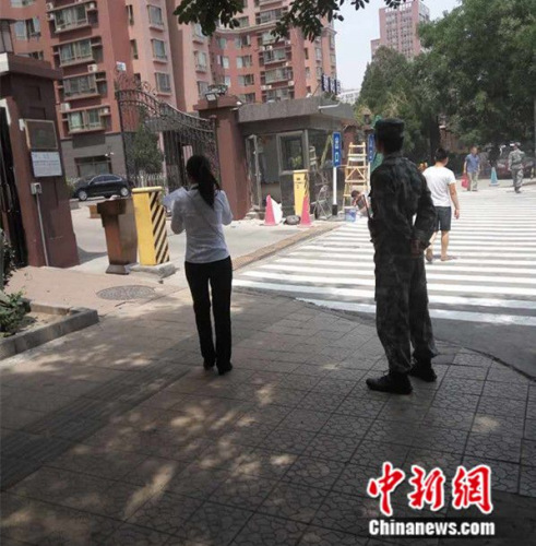 5月30日中午，在北京朝阳区青年路附近的某小区，一名保安穿着迷彩制服站岗。吕春荣摄