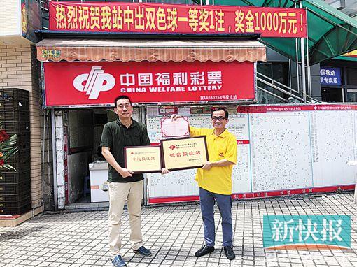 ■珠海市福彩中心主任吴克坚(左)向陈强华(右)颁发“诚信投注站”牌匾。