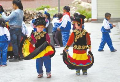 26日,支尔莫乡勒尔小学,两名穿着民族服饰的孩子。