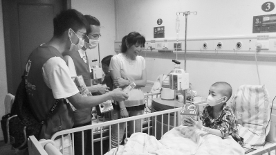 ▼志愿者们给住院的白血病患儿送六一节礼物。