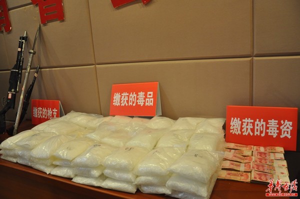 警方缴获的枪支、毒品和毒资。