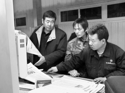 　　陈国胜（左一）在南阳大河印务公司开机印刷现场。本报资料图片