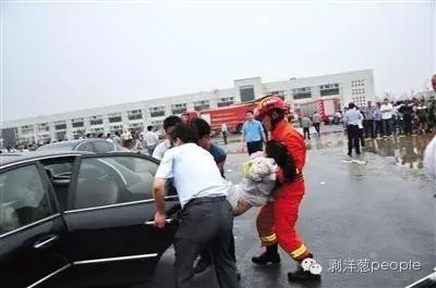 消防队员和民众一起把伤员抬上车。图片来自网络