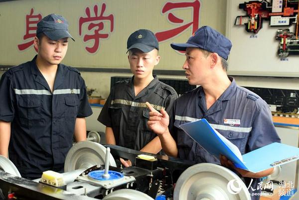 罗明铭在现场给青工传授业务知识。