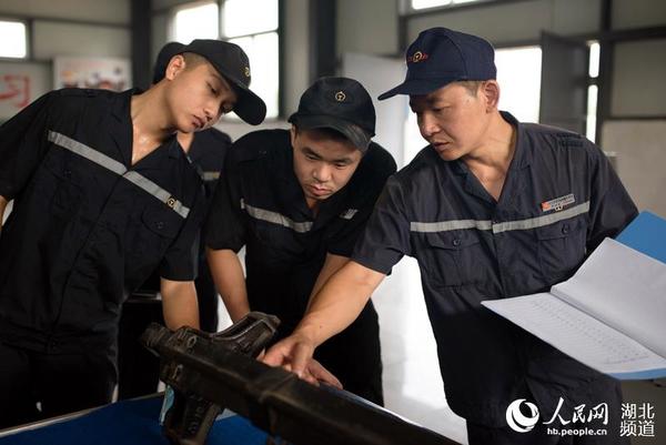 罗明铭指导青工识别制动梁裂纹故障技术。