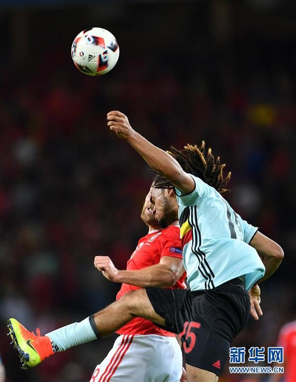 7月1日,威尔士队球员沃克斯(红衣)在比赛中和比利时队球员德纳耶尔拼抢。