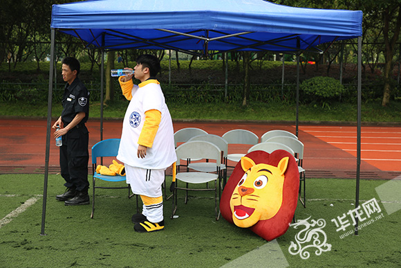 天气闷热，穿着厚厚活动服装的工作人员喝水降温。 记者 刘嵩 摄