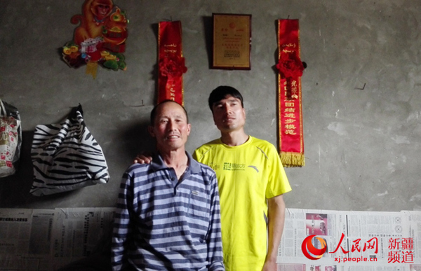 李金明、图尔迪父子在一起。记者杨明方摄