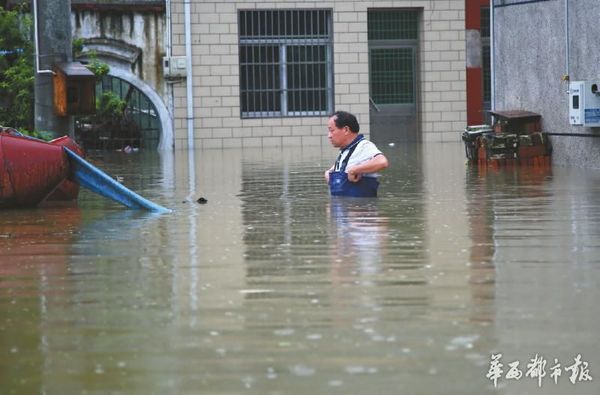 7月3日，江苏常州武进区牛塘镇丫河村一名村民在水中艰难行走。