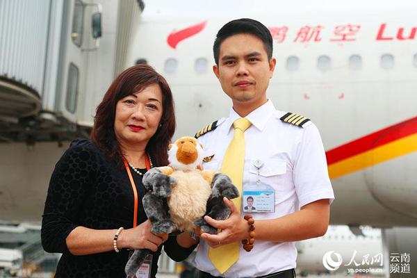 马来西亚旅游局广州办事处处长何素银向执飞昆明=沙巴航线首航航班机长符方一赠送沙巴吉祥物。(供图)