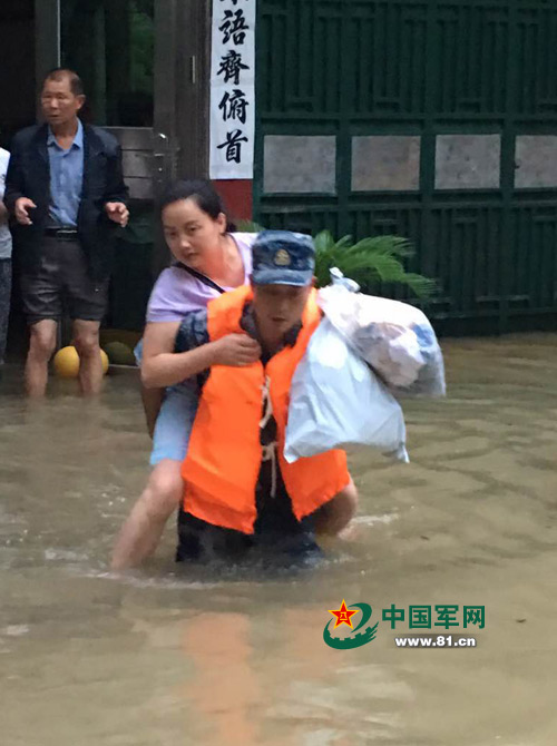 齐腰深的洪水中，官兵解救受灾群众。张垚 摄