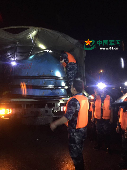 接到驰援下一地点命令后，官兵们马不停蹄地装载救援工具。张垚 摄