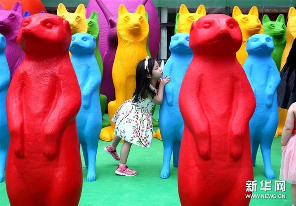 7月7日，小朋友在动物雕塑中间玩耍。新华社记者 陈飞 摄