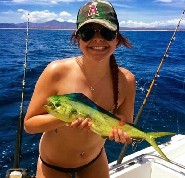 在“钓鱼胸罩”热潮中，各种尺寸的鱼类都有，从巨大的金枪鱼到小鳟鱼。图中这名女子抱着的是鲯鳅鱼。（网页截图）