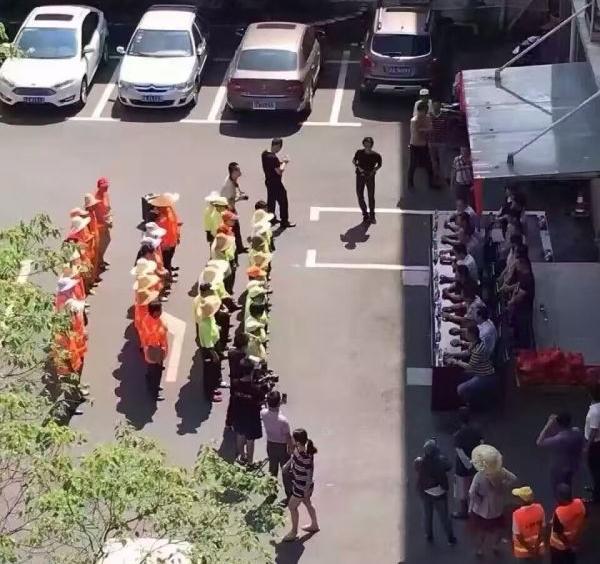 8月11日，江西南昌市青山湖区举行慰问环卫工人的爱心活动，图片中环卫工人站在烈日下，等待着坐在旁边阴凉处的领导们发放慰问品。图片来自网络