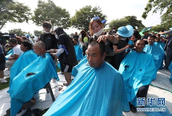 　　当地时间2016年8月15日，韩国庆尚北道星州郡，当地民众举行集会，要求取消部署萨德。部分抗议者“剃发”表不满。图片来源：视觉中国