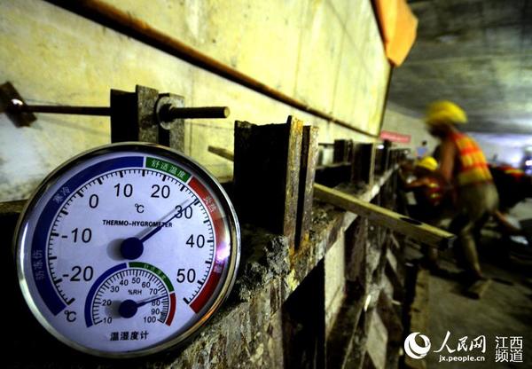 南昌红谷隧道的施工现场离地面约20米深，这里的温度接近30℃，不要以为这里很凉爽，其实闷热难当，高湿度的环境让湿度计的指针飘红，不超过15分钟，拍摄人员已经汗流浃背。