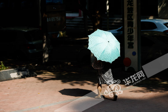早上10点骄阳似火，市民纷纷撑伞出行。记者 石涛 摄