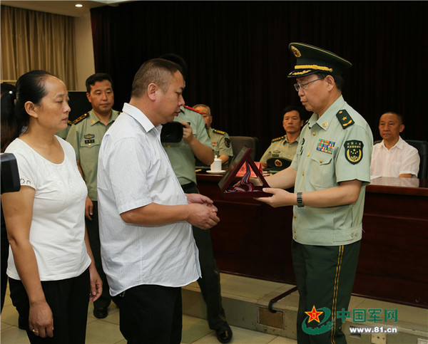 武警交通部队许世宏政委为烈士家属颁发奖章.涂敦法 摄