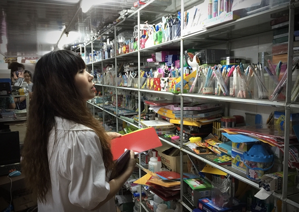 图说：一名家长正在为孩子挑选文具。来源：视觉中国