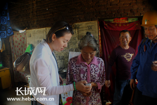 帮扶支援小组成员指导村民使用遥控智能照明灯。
