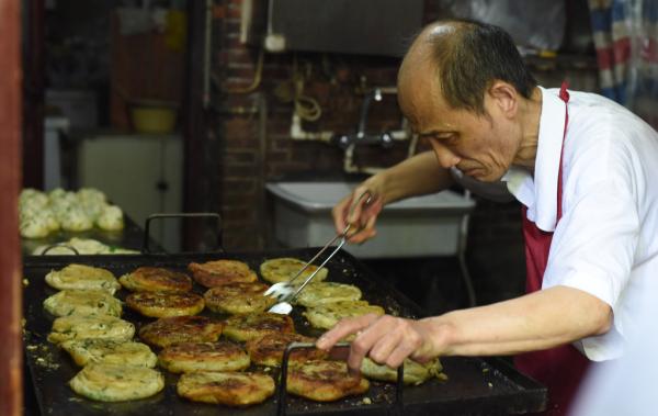 　　9月26日，上海南昌路，阿大正在做葱油饼。 澎湃新闻记者张新燕 实习生 刘嘉炜