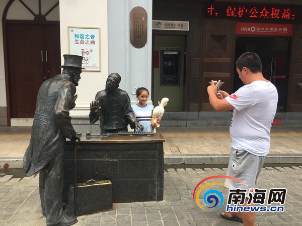 　　“十一”黄金周首日游客带孩子在骑楼老街内的雕塑前拍照留念。南海网记者徐静涵摄