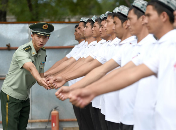 沪疆两地武警升旗手和维吾尔族青年的国旗情