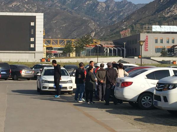 10月3日上午，在五台山风景名胜区游客中心停车场内，当地黑导游正与游客&rdquo;洽谈业务&ldquo;，称正规购票后按人头收取每人100元，可将车带入景区，自己藏在汽车后备厢内。  本文图片均为澎湃新闻记者王哿图