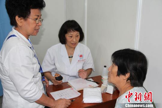 来自北京中医药大学东直门医院针灸科的刘颖(中)主任医师为印尼民众义诊。 顾时宏 摄