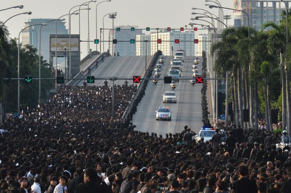 14日，曼谷街头，大批泰国民众在等待搭载普密蓬国王灵柩的车队通过。(法新社)