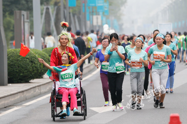 妻子在比赛前受伤,推着轮椅也要跑完十公里。记者 石涛 摄