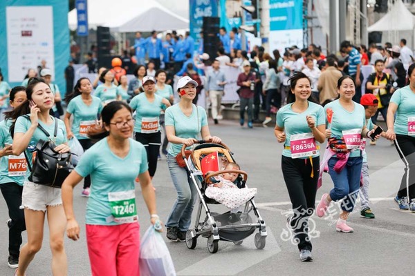 宝宝坐稳了,妈妈带着你向前冲。记者 石涛 摄