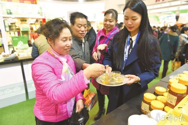 成都市民品尝大凉山纯天然蜂蜜。