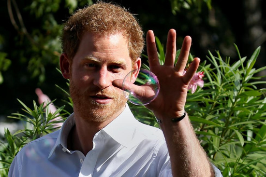 哈里王子在抓泡泡。图片来源：路透社。
