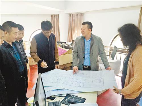 谭学田(右二)正与员工讨论工作。